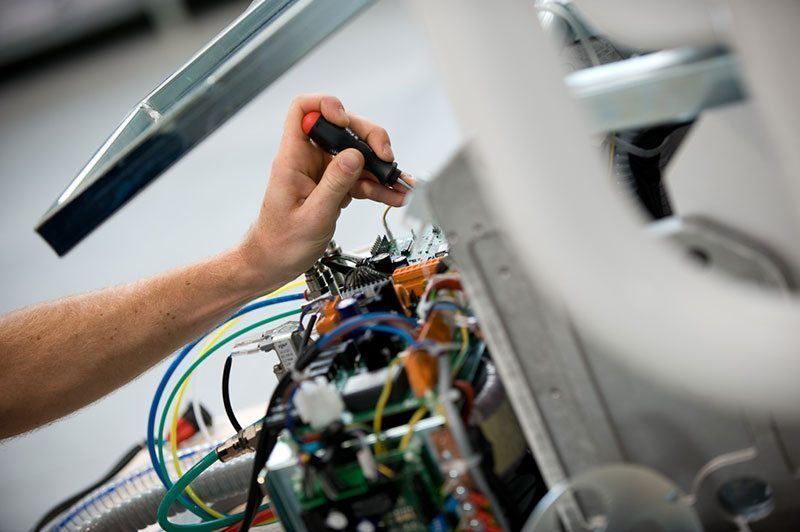 Manutenção técnica em equipamento odontológico com componentes eletrônicos expostos